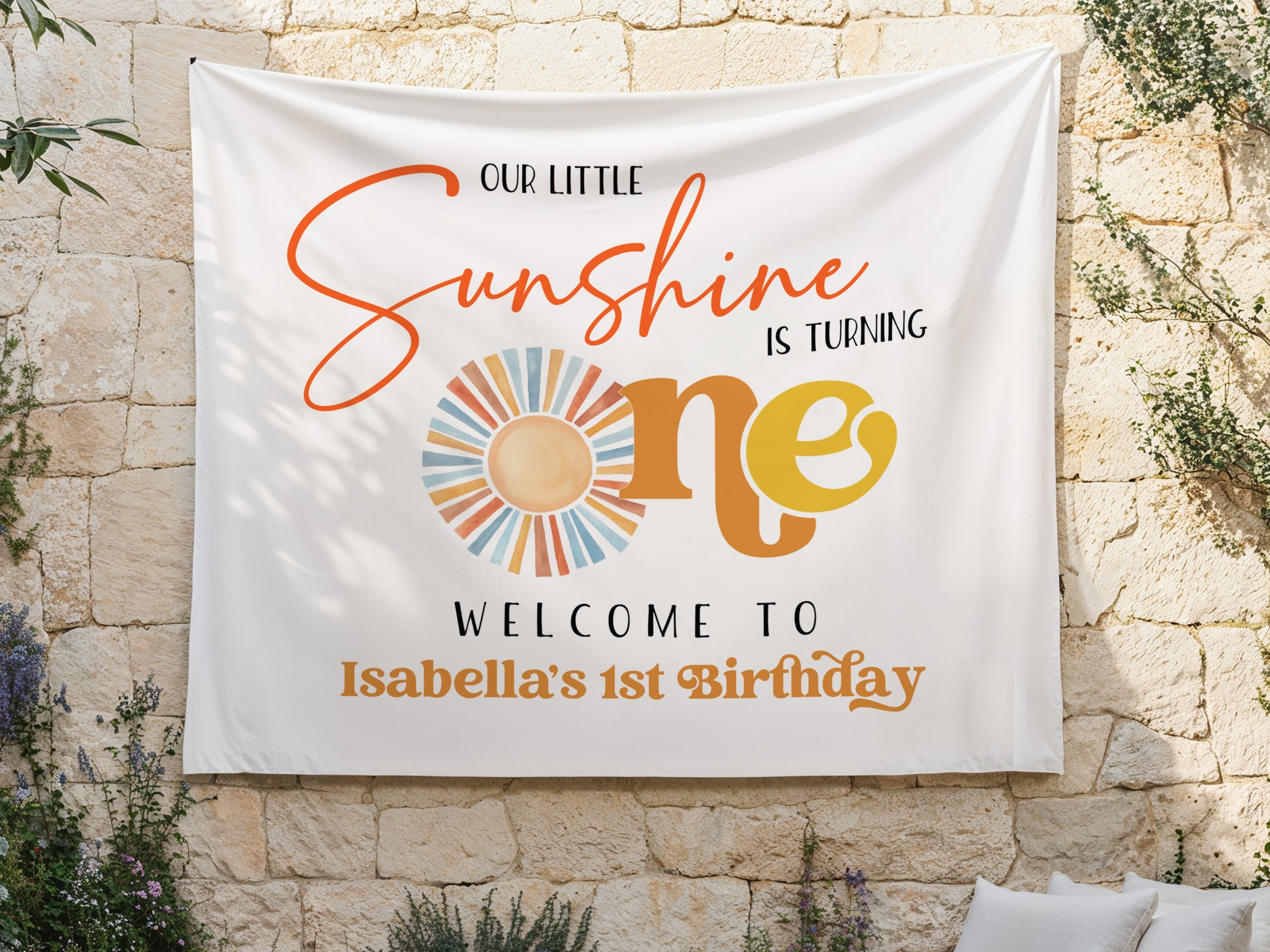 Birthday banner with 'Our Little Sunshine is Turning One' text on a white backdrop fabric and hang on a stone wall background
