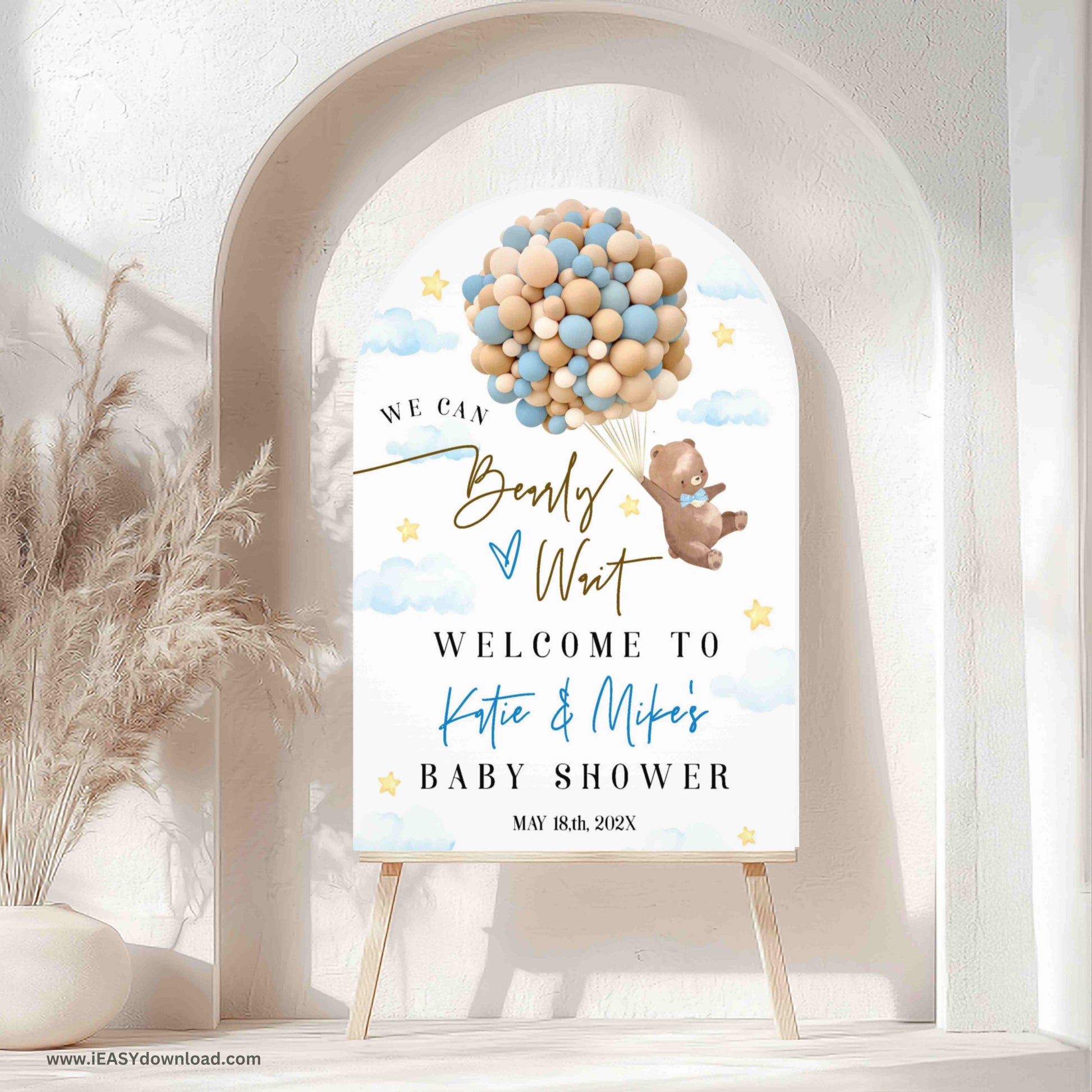 Baby shower welcome sign with balloons and teddy bear design in a decorative setting.