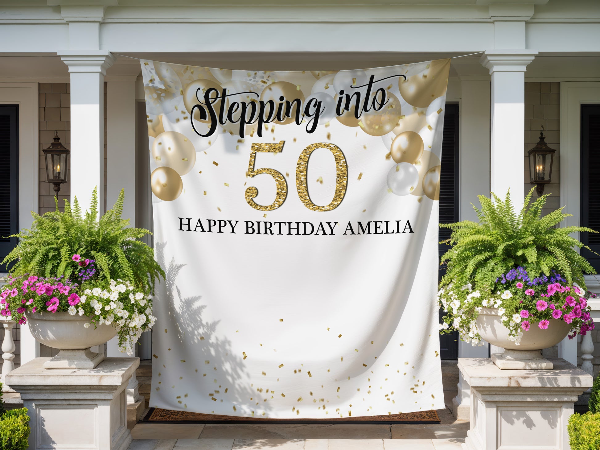 Decorative banner for a 50th birthday celebration with balloons and flowers on a house exterior.