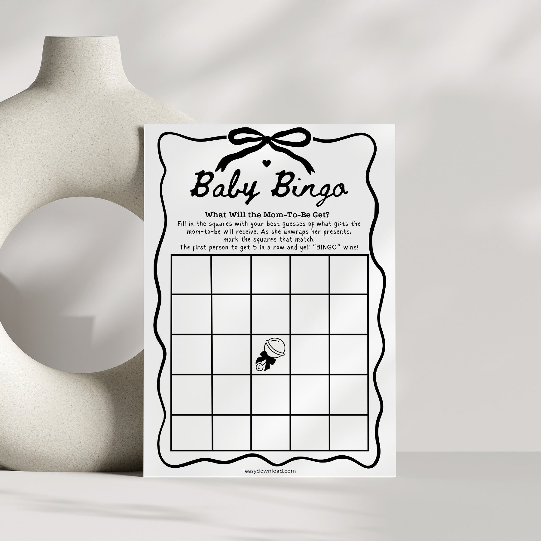 Baby shower game card for 'Baby Bingo' on a white surface with a neutral background