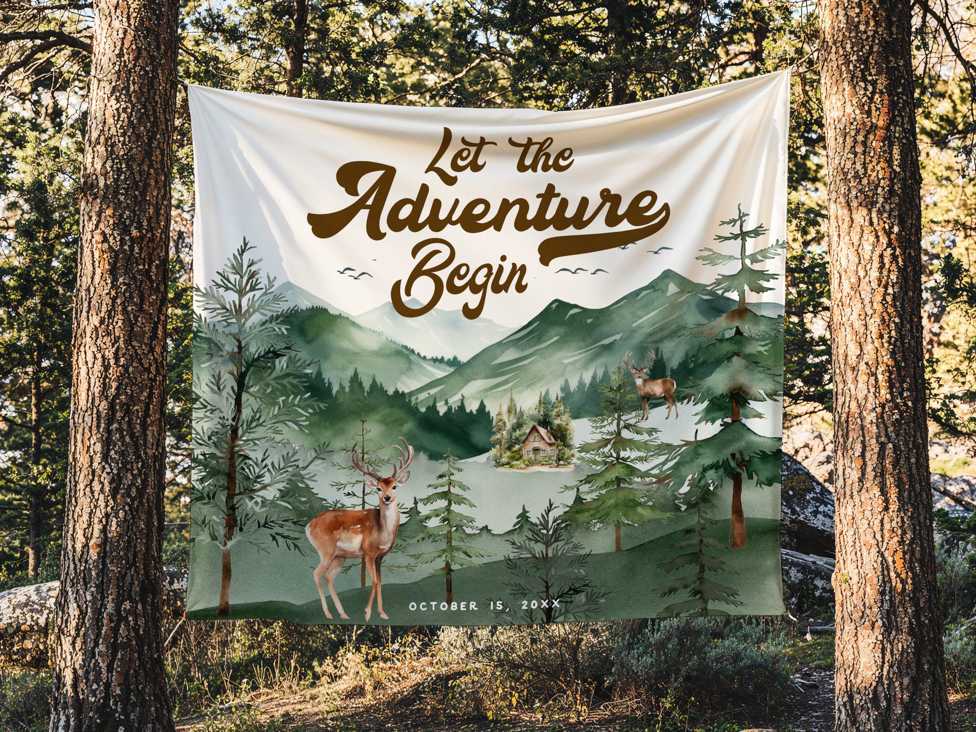 Decorative banner with 'Let the Adventure Begin' text and nature scene, hanging between two trees in a forest.